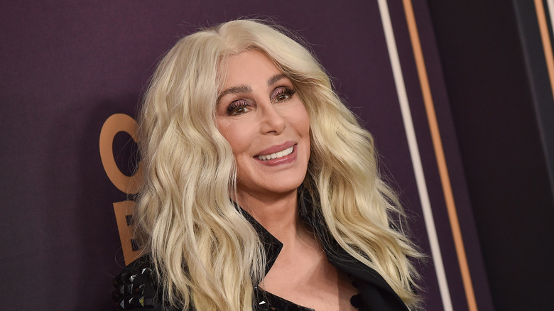 A blonde-haired Cher smiles for the camera