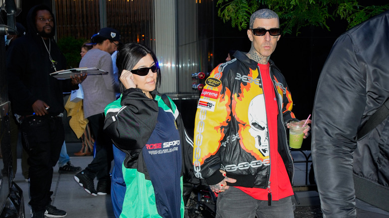 Kourtney Kardashian and Travis Barker rock sunshade and bright clothing on a stroll