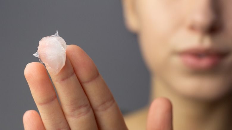 Dab of petroleum jelly on woman's finger