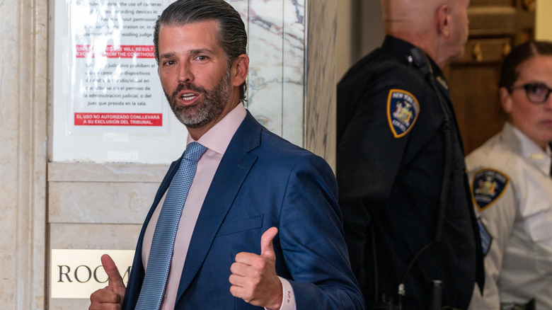 Donald Trump Jr. showing a double thumbs-up at the camera