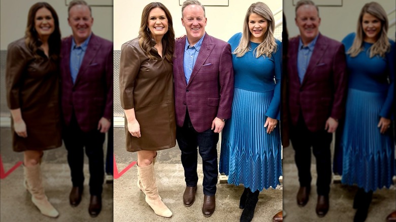 Sarah Huckabee Sanders posing with Sean Spicer and Hannah Stone; Huckabee Sanders is wearing a stiff, no-shape leather dress.