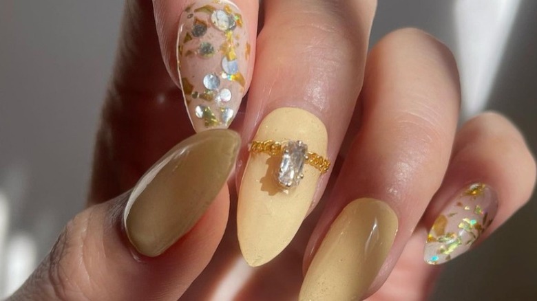 Manicure with mustard yellow nails and gemstones
