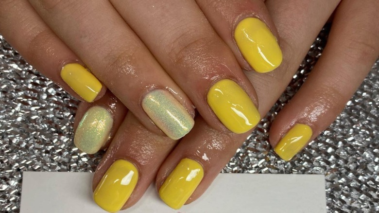 hands with yellow nail polish