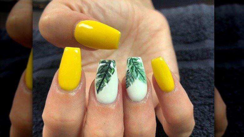 Yellow manicure with leaf nail art
