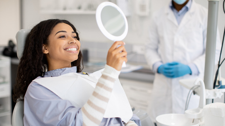 woman admiring her teeth at the dentist