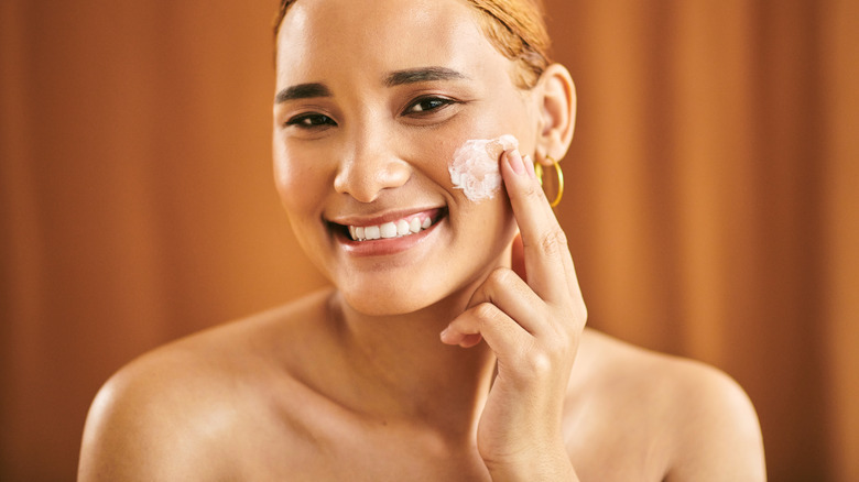 Woman applying moisturizer