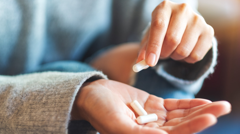 closeup of woman holding supplement capsules