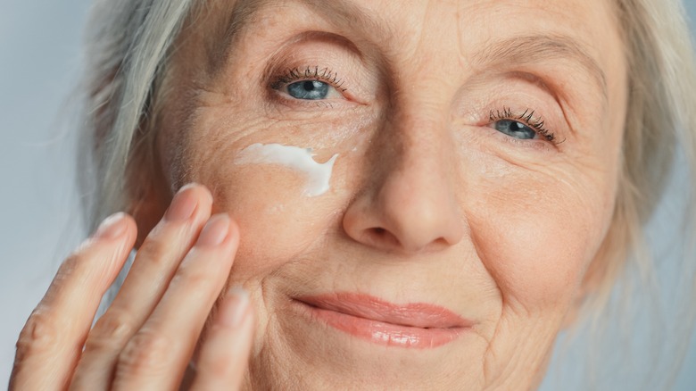 elderly woman applying face cream