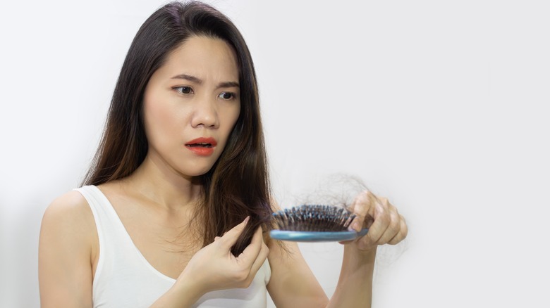 woman looking at her damaged hair