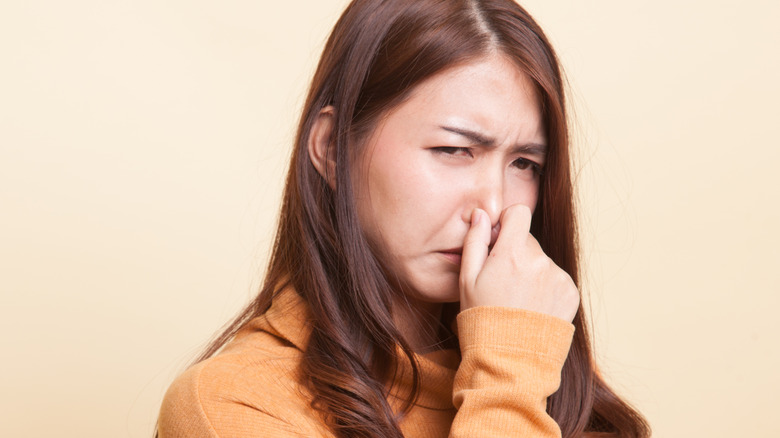 Woman holding nose