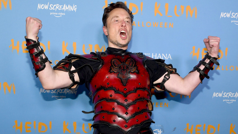 Elon Musk posing on the red carpet in a costume at Heidi Klum's Halloween party