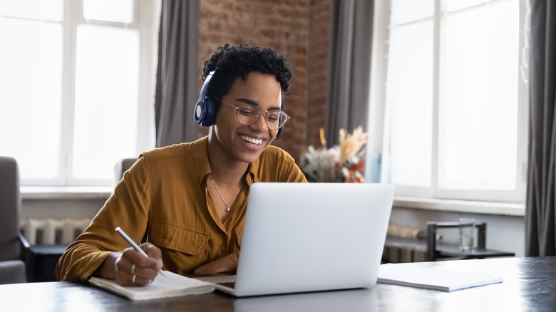 Woman smiling working on laptop