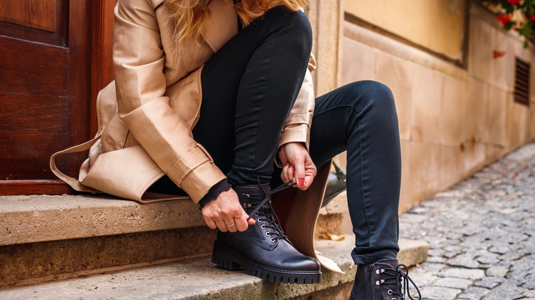 woman tying shoe laces outside