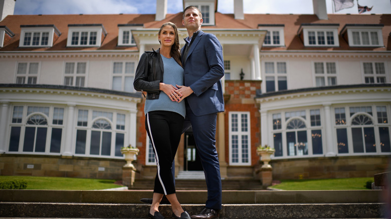 Eric and Lara Trump standing with their hands together on Lara's stomach