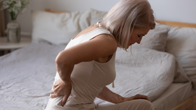 Older woman sitting on bed