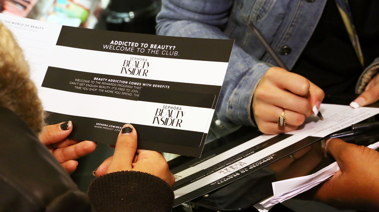 person holding Sephora beauty insider card