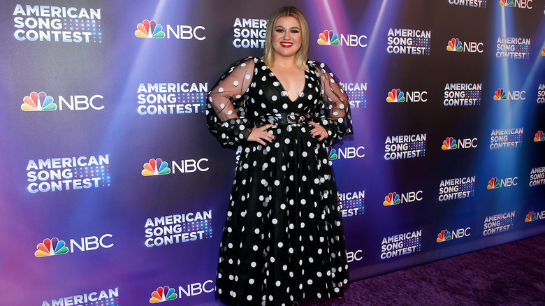 Kelly Clarkson posing in a black at white polka dot dress for NBC's "American Song Contest" at The Lot at Universal Studios Hollywood on March 21, 2022 in Universal City, California