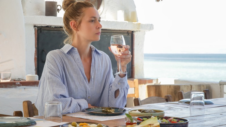 woman drinking wine at table