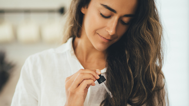 woman putting oil in her hair