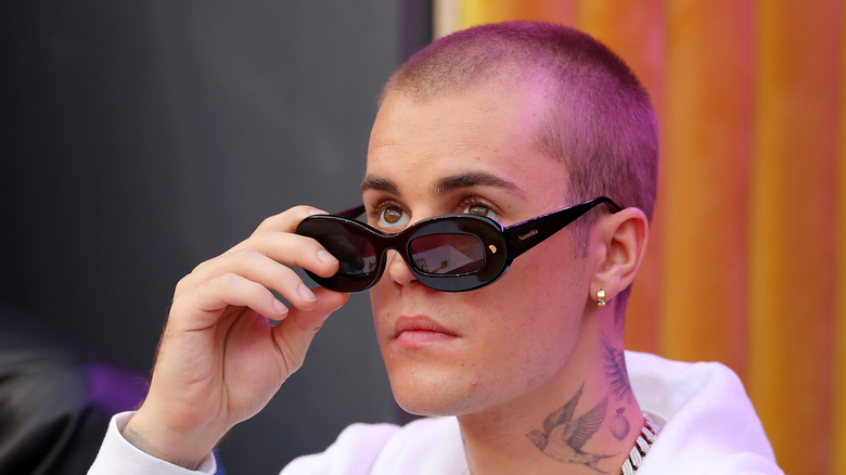 Justin Bieber lowering his sunglasses