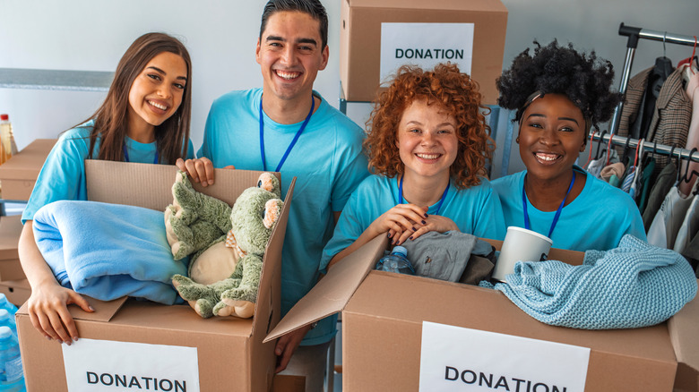 Group of young people standing behind donations