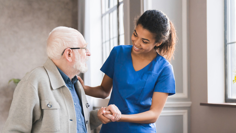 Young nurse helping older man