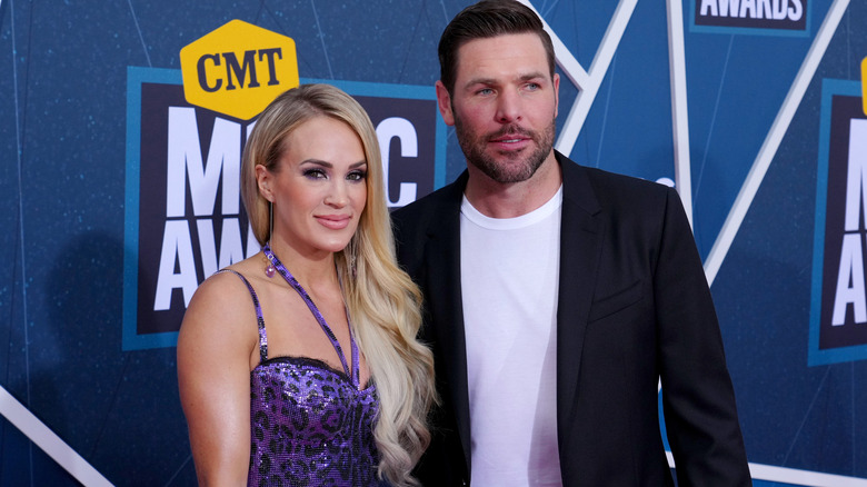 Carrie Underwood and Mike Fisher posing for photos