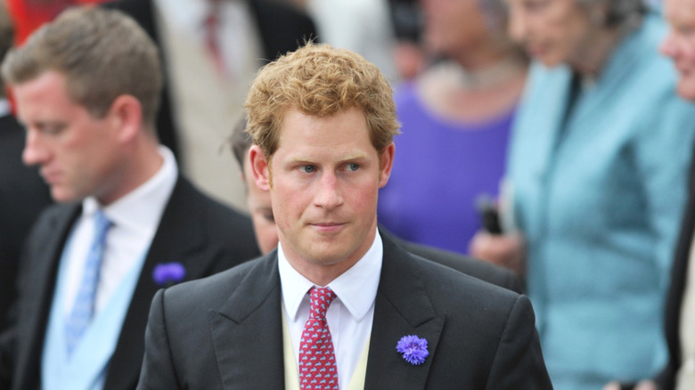 Young Prince Harry stares left in black suit