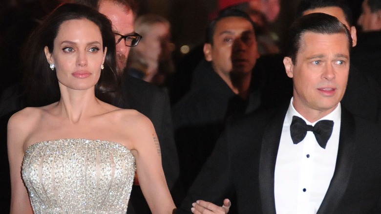 Angelina Jolie holding Brad Pitt's arm