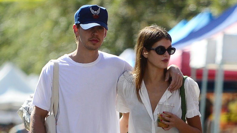 Austin Butler with his arm around Kaia Gerber as they walk