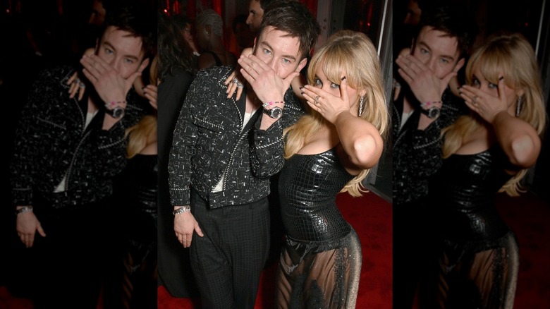 Barry Keoghan and Sabrina Carpenter covering their mouths at the 2024 Vanity Fair Oscar Party