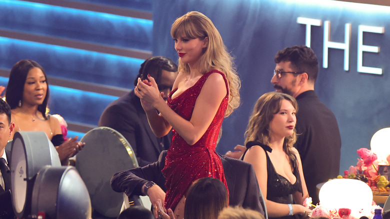 Taylor Swift clapping at the 2025 Grammy Awards in a sparkly red dress in Los Angeles, California