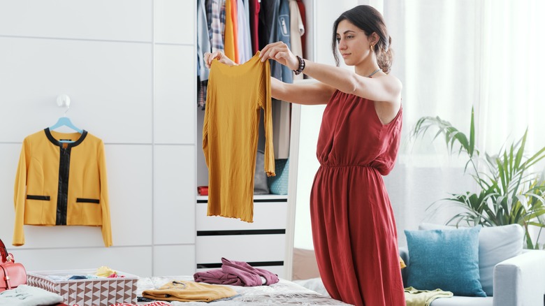 Woman sorting clothes in bedroom