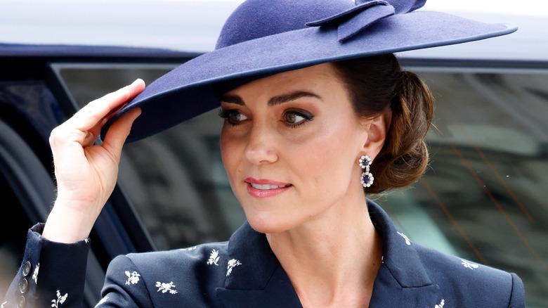 Kate Middleton holding brim of hat