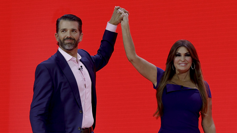 Donald Trump Jr. and Kimberly Guilfoyle raising each other's hands