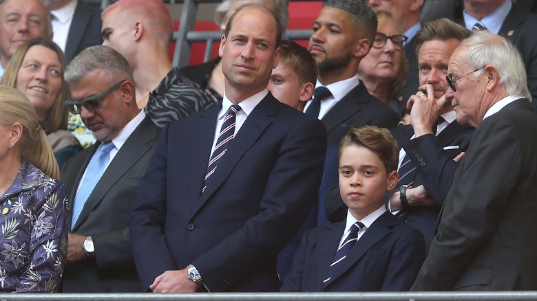 Prince William standing next to Prince George