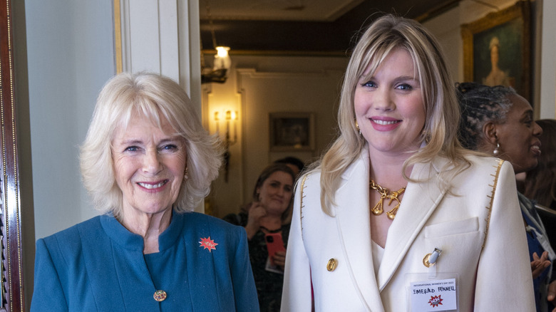 Camilla smiles with Emerald Fennell at a reception to mark International Women's Day at Clarence House in London, England (2022)