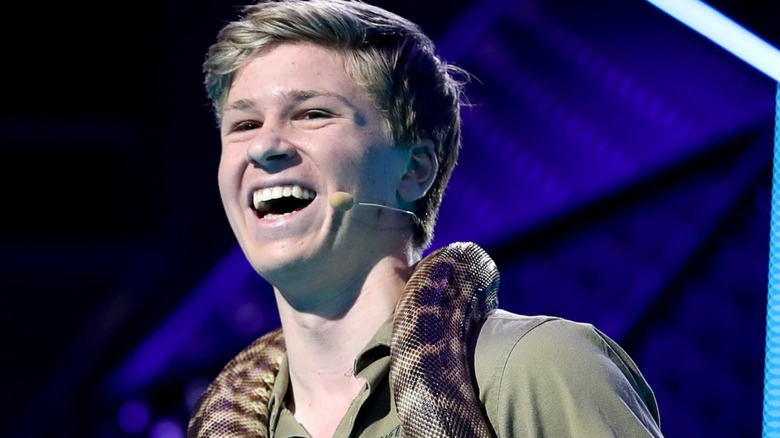 Robert Irwin smiling, snake on shoulders