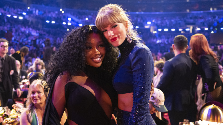 Taylor Swift and SZA smiling with their arms around each other