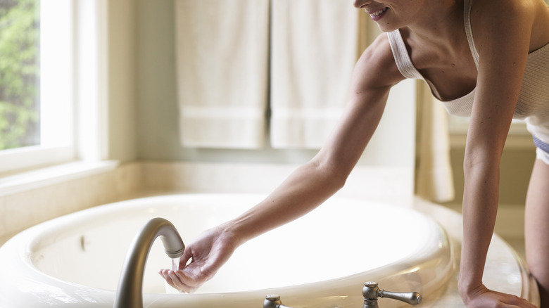 woman testing bathtub water