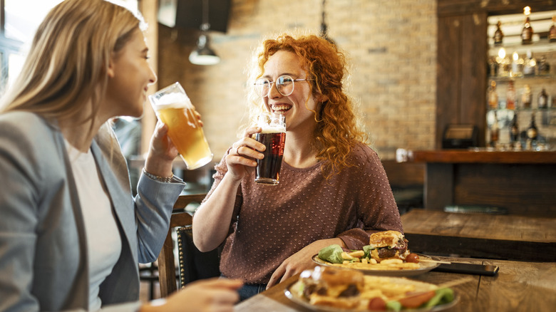 smiling women drinking at dinner 