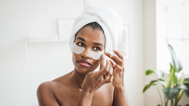 Woman applies eye masks to face