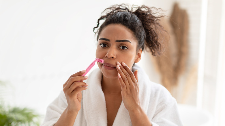 Woman uses razor on her upper lip