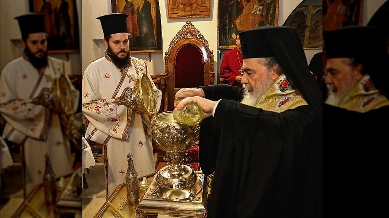 Priest pouring holy oil