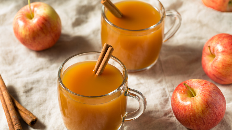 mugs of apple cider and apples