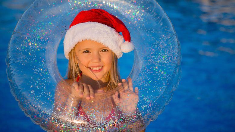 girl in santa hat at pool