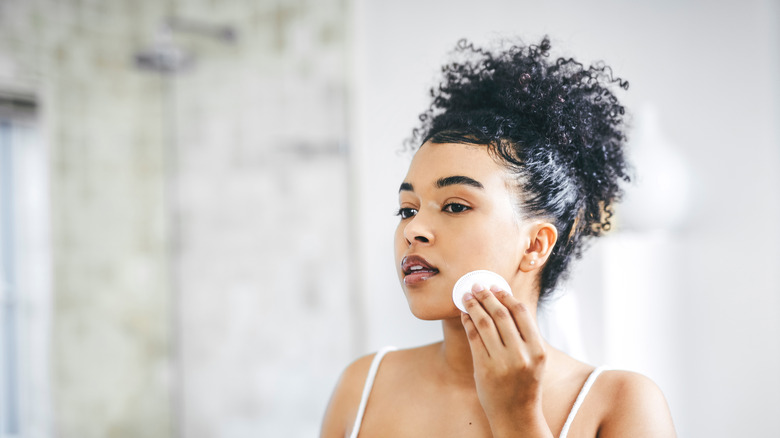 Wiping face with cotton pad