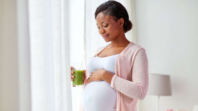 pregnant woman drinking green smoothie