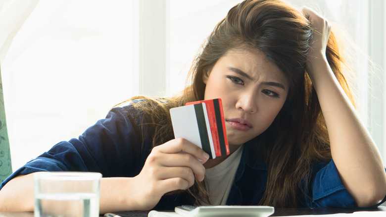 woman in debt holding credit cards