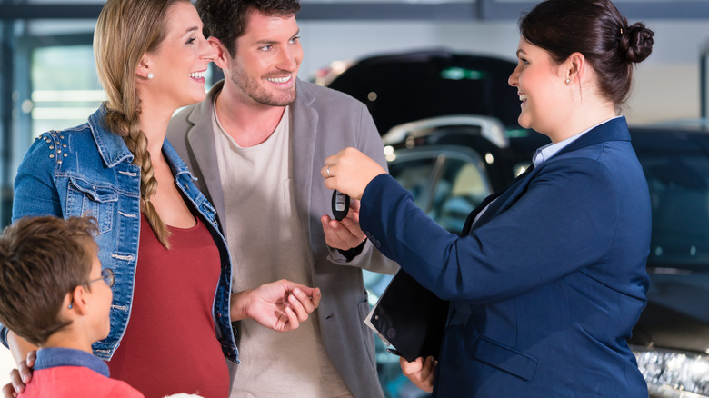 pregnant woman with family buying a car